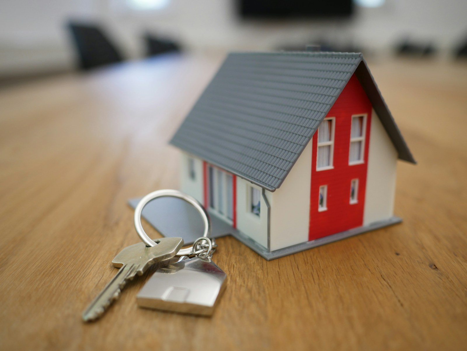 Model of a house and keys on a table, symbolising access to property